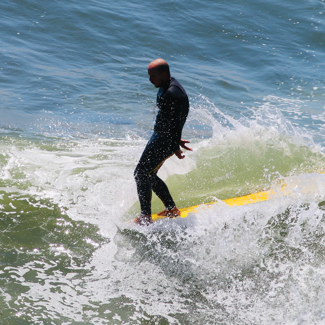Surfer on a longboard with a waxless grip