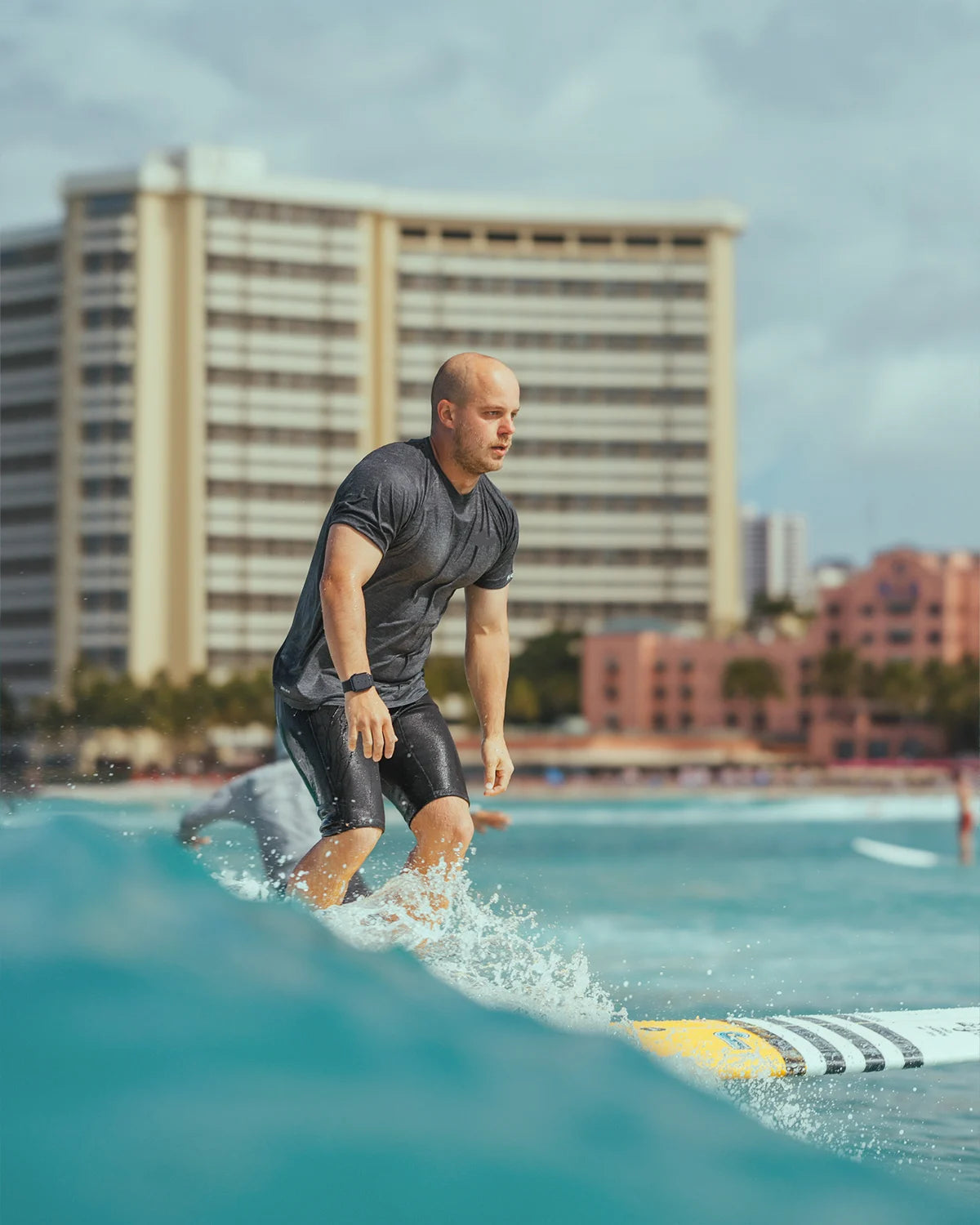Surfing a longboard with a cityscape 